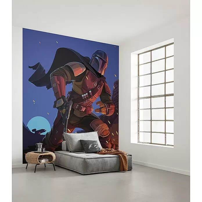 Komar Star Wars Fototapete Mandalorian Big Ambush - 5 -tlg., B x H: 250 x 280 cm, Vlies - Ein Zimmer mit großer Mandalorian-Wandtapete, grauer Stoff-Chaiselongue und geflochtenem Beistelltisch mit Kaffee und Büchern.
