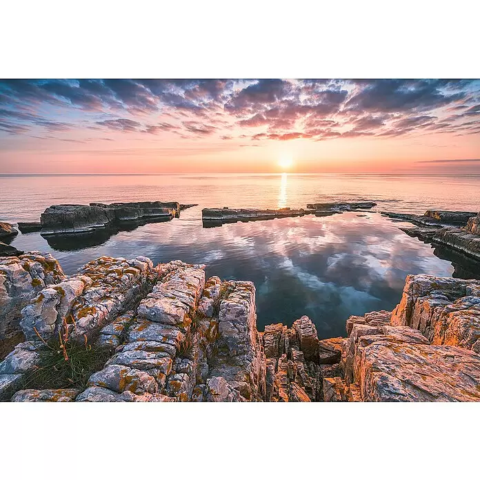 Komar Home Fototapete Spiegelküste - 4 -tlg., B x H: 368 x 248 cm, Vlies - Lebhafter Sonnenaufgang über ruhigem Meer mit felsiger Küste. Orange-rosa Wolken spiegeln sich im Wasser, beleuchten die Felsen.