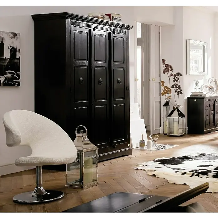 Komar Dekosticker Lady's Smock - 6 -tlg., 70 x 50 cm - Elegantes Interieur mit einem schwarzen Kleiderschrank, einem weißen Sessel und dekorativen Elementen wie Laternen und einem Kuhfellteppich.