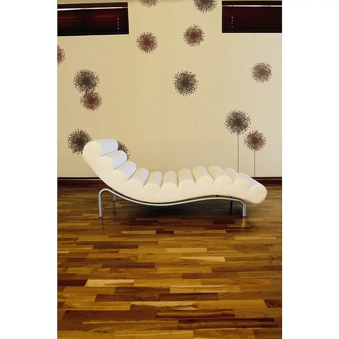 Komar Dekosticker Pusteblume - 4 -tlg., 70 x 50 cm - Nahaufnahme einer modernen, weißen Liege mit gerollter Polsterung und Metallgestell, die auf einem Holzboden vor einer gemusterten Wand steht.
